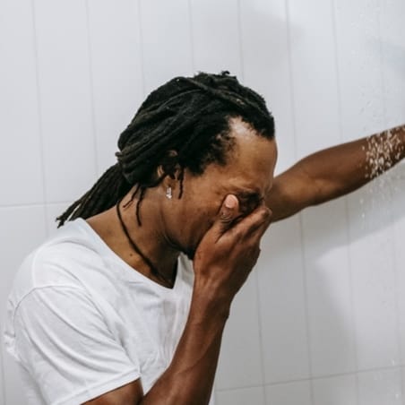 a man crying in the shower suffering from emotional abuse